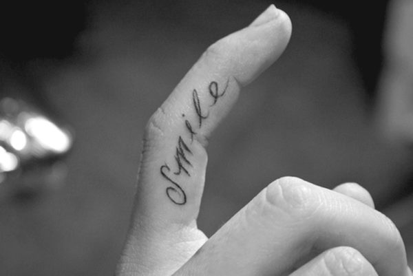 Black And White Smile Tattoo On Finger