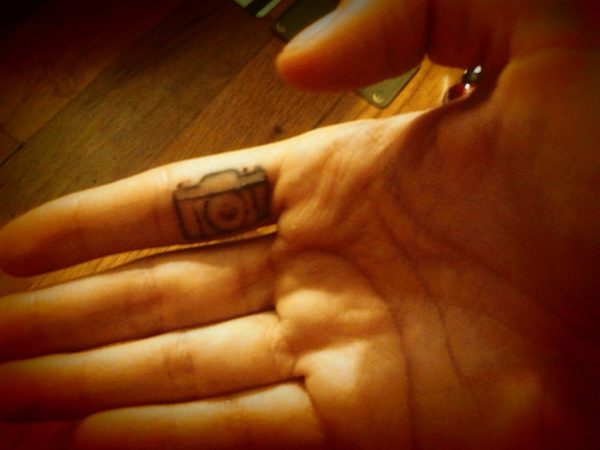 Black Camera Tattoo On Inner Finger