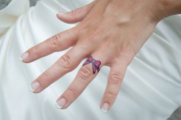 Pink Bow Tattoo On Ring Finger