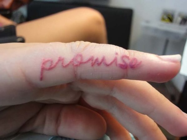 Red Colored Promise Tattoo On Finger