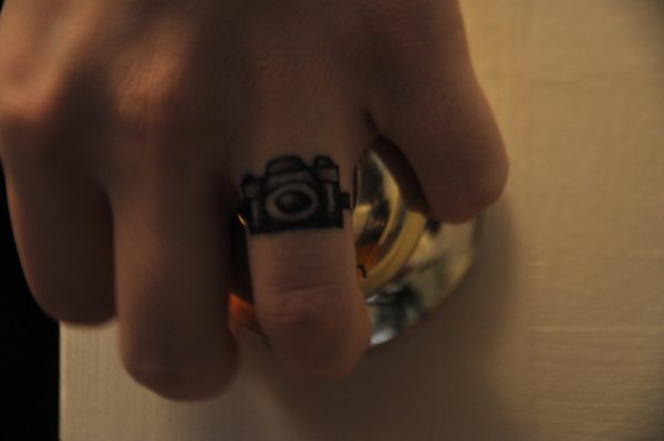 Small Camera Tattoo On Finger