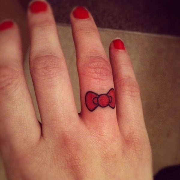 Small Red Bow Tattoo On Finger